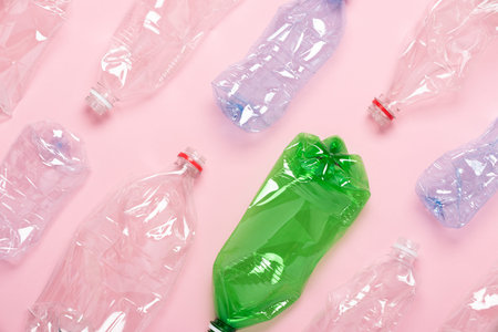 Plastic bottles on pink background top view. Plastic recycling concept.