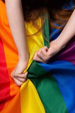 Woman hands pull rainbow Pride flag sex orgasm sign conceptの写真素材