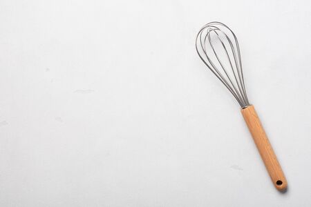 Whisk cooking egg beater mixer whisker new clean with wooden handle on stucco table top viewの写真素材