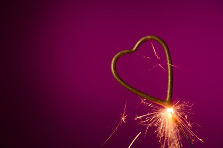 Burning sparkler in shape of heartの写真素材