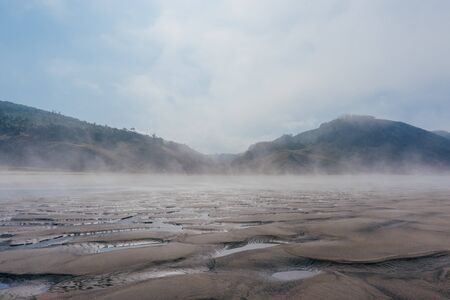 Beach in fog with puddles during ebbの写真素材