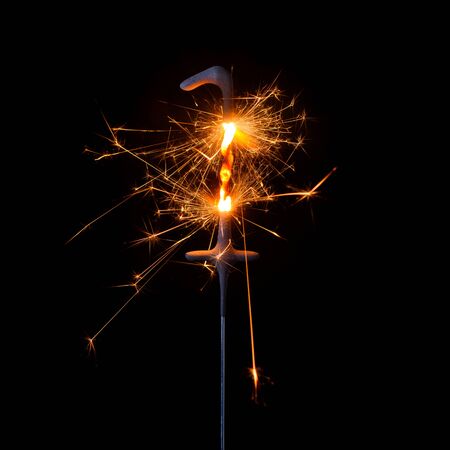 Burning sparkler in shape of number one, digit 1, isolated on black background.の写真素材