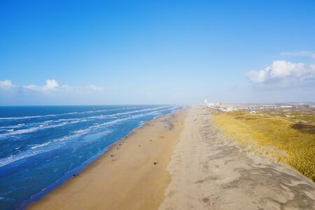 People walking on a north sea sandy beach near Zandvoort, Netherlands, aerial drone viewの写真素材
