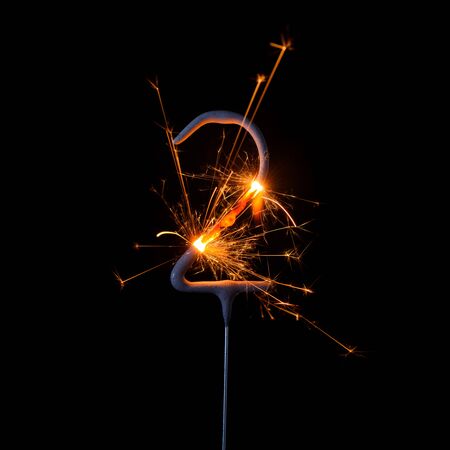 Burning sparkler in shape of number two, digit 2, isolated on black background.の写真素材