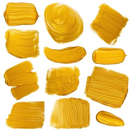 Gold paint brush strokes smugdes set. Golden metallic foil color painted design elements collection isolated on white background.の写真素材