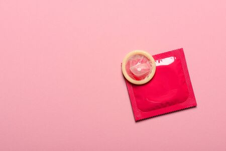 Condom with packaging on pink pastel background with copy-space.の写真素材