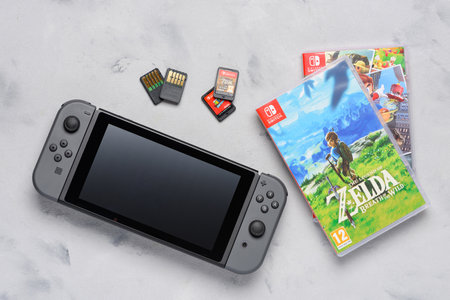 Krakow, Poland - Januray  14, 2020:  Switch gaming console with popular Zelda and Mario games and game cards flat lay on table. Illustrative editorial.のeditorial素材