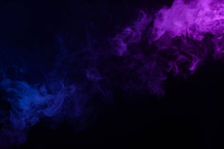 Multicolored smoke or fog blue and purple on black backgroundの写真素材