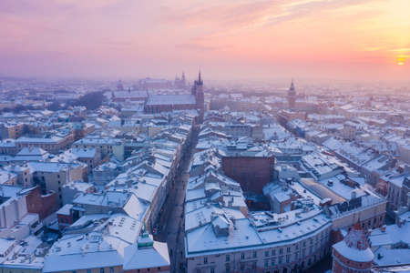 Krakow Old Town in winter. Snow on roofs at Old Town in winter Krakow Poland at sunset. Historical main city square Rynek, Royal Road and churches. Snow on roofs in winter Krakow Poland at sunset.の写真素材