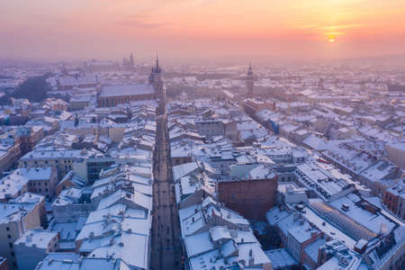 Krakow Old Town in winter. Snow on roofs at Old Town in winter Krakow Poland at sunset. Historical main city square Rynek, Royal Road and churches.の写真素材