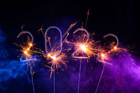 2022 Happy new year greeting card with with sparklers shiny glitter and colorful smokeの写真素材