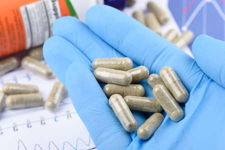Supplement capsules in scientist handの写真素材