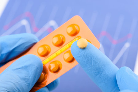 Scientist hold small pill on fingertip of one hand and blister pack in other. New medical treatment...