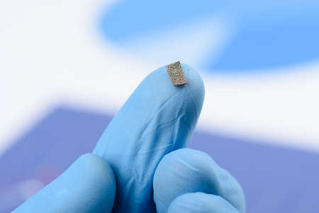 Piece of cellular fiber material on scientist fingertip. Research for material or coating with new properties concept.の写真素材