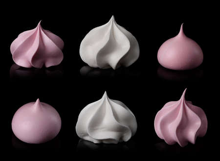 Meringue cookie set isolated on black background. Twisted sweet crispy curly white and pink meringue with reflection.の写真素材