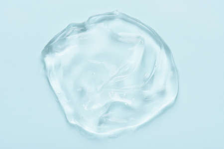 Clear cosmetic skincare gel with bubbles on blue background top viewの写真素材