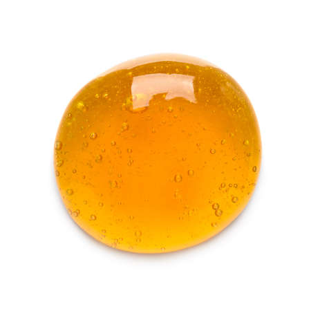 Drop of honey with bubbles isolated on white background top viewの写真素材