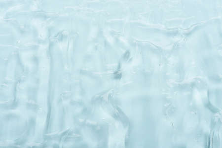 Clear cosmetic skincare gel with bubbles on blue background texture top viewの写真素材