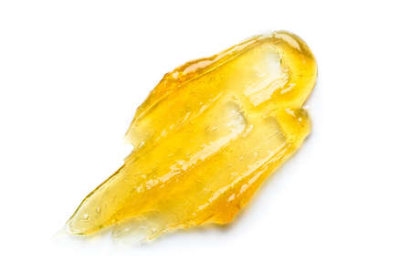 Golden honey or clear yellow gel serum smear with bubbles isolated on white background top viewの写真素材
