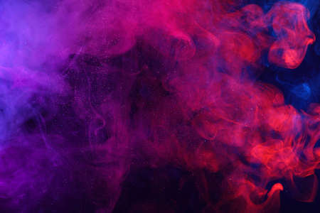 Pink and blue colorful smoke clouds and shiny glitter powder particles abstract backgroundの写真素材