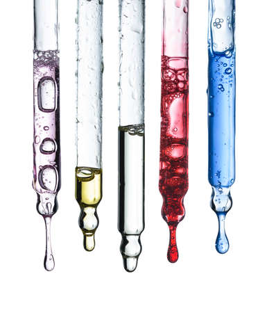 Five glass cosmetic pipette droppers set with different colored skincare serum and hanging liquid drop, isolated on white backgroundの写真素材