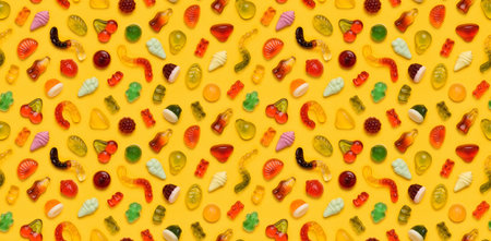 Seamless pattern of assorted jelly gum fruit candy on yellow background top view flat layの写真素材