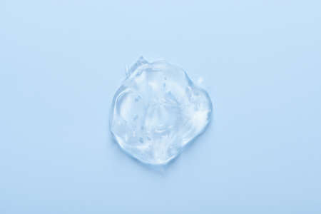 Clear transparent cosmetic skin care gel serum smear with bubbles isolated on blue background top viewの写真素材