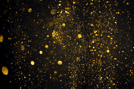 Shiny golden glitter bokeh lights on black abstract backgroundの写真素材