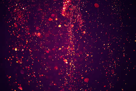 Abstract bokeh background of purple festive glitter lights dust particlesの写真素材