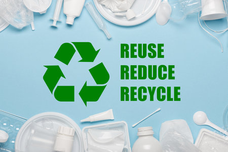Recycling sybmol with reuse reduce recycle slogan surrounded by single-use plastic objects, packaging plastic products on blue backgroundの写真素材
