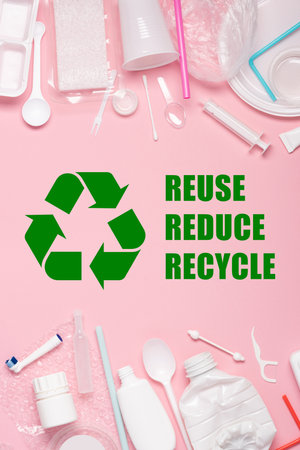 Plastics on pink pastel background with recycling symbol and reuse reduce recycle textの写真素材