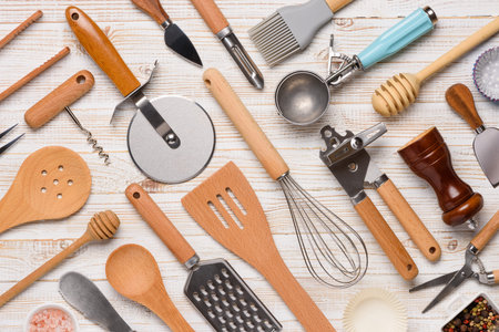 Set of kitchen utensils pattern on white wooden table background top view. Various cooking tools...