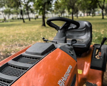 Ho Chi Minh City, 16 March 2021: Used orange riding lawn mower on the grass in the park, close up shot.のeditorial素材