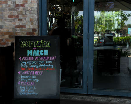 Ho Chi Minh City, 25 March 2021:  Hand-written blackboard chalk menu outside in front of restaurant glass doorのeditorial素材