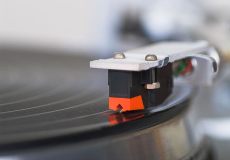Macro shot of 20 years old turntable tone-arm cartridge playing disk. You can put you logo on it.