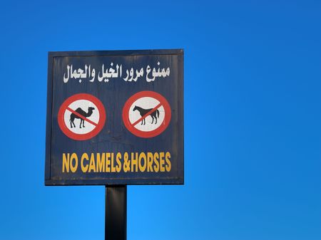 Blue Grunge Sign No Camels and Horses in Arabic and English against deep blue sky. Clipping path included.の写真素材