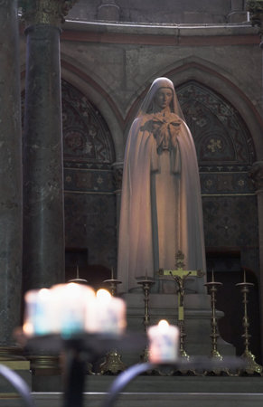 Virgin Mary Statue in Church with burning candles in the foregroundのeditorial素材