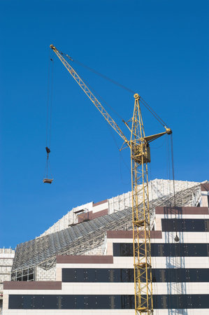Construction of new city building with tower crane on the foreground