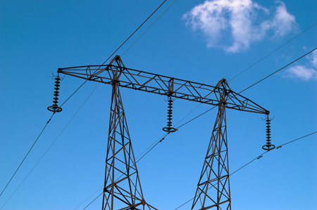 High-voltage power transmission tower over blue sky