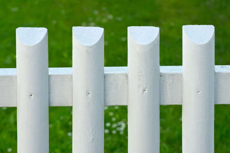 White batten fence with green grass on backgroundの写真素材