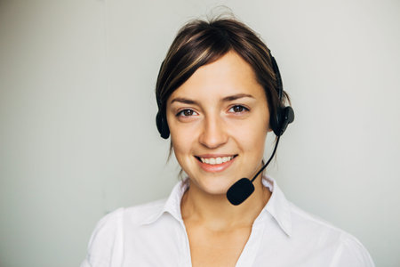 Closeup of a beautiful business customer service woman smiling on white background