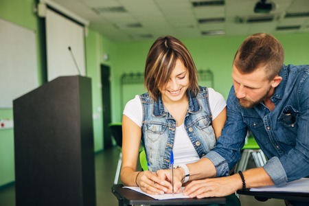 student helps her friend to lectures at the univesityの写真素材
