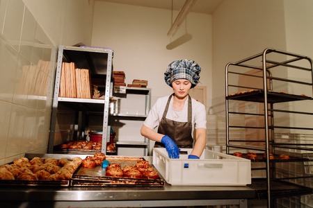 Baking tray with cinnamon buns,the Baker removes rollsの写真素材