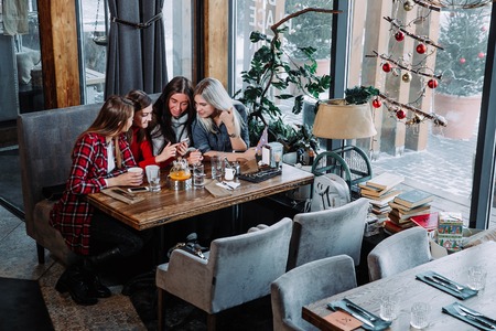 four friends look at the phone and laughの写真素材