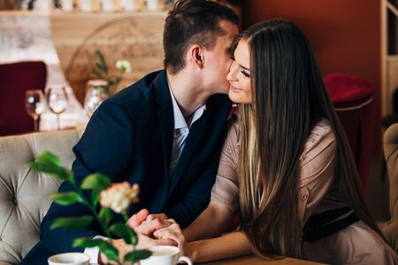 Couple in love kissing at bar eating in restautantの写真素材