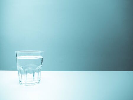 A glass of water with pastel blue backgroundの写真素材