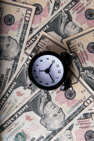 Alarm clock above the dollarsの写真素材