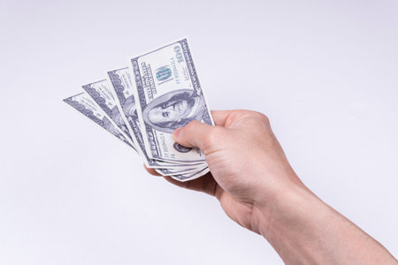 A hand holding a dollar