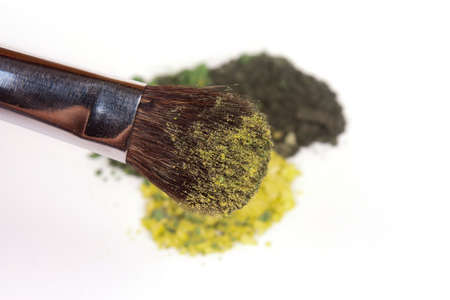Green eyeshadow palette with brush on white background の写真素材
