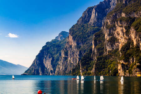 Riva del Garda, Trentino Alto Adige / Italy - September 24 2017: Small yachts sail on the lake against the backdrop of the mountains.のeditorial素材